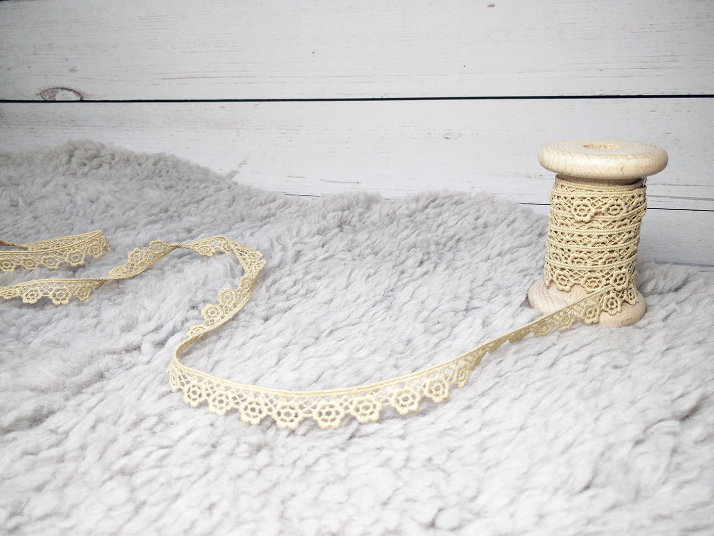 Beige Spitze Blümchen 13mm auf Holzspule, perfekt für DIY-Projekte und Bastelarbeiten.