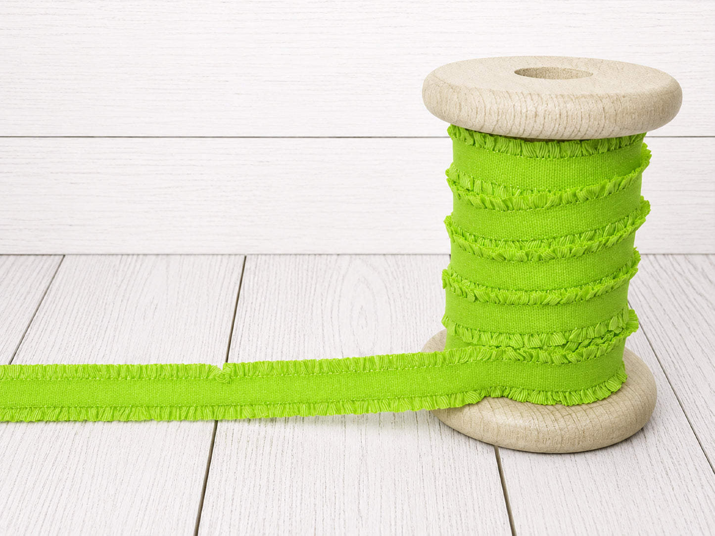 neongrün rüschen gummiband kaufen auf einer Holzspule mit feiner Rüschenstruktur für kreative Nähprojekte.