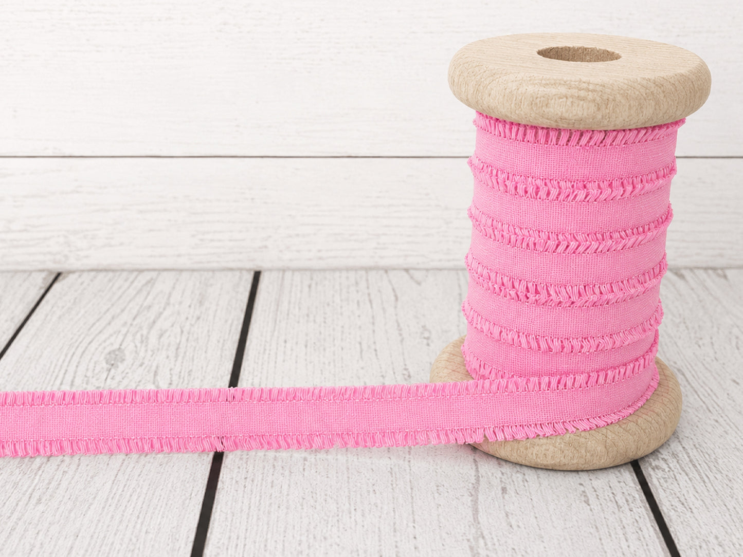 Rüschen Gummiband - rosa auf einer Holzspule, 100% Polyester, Breite ca. 14 mm für Nähprojekte.