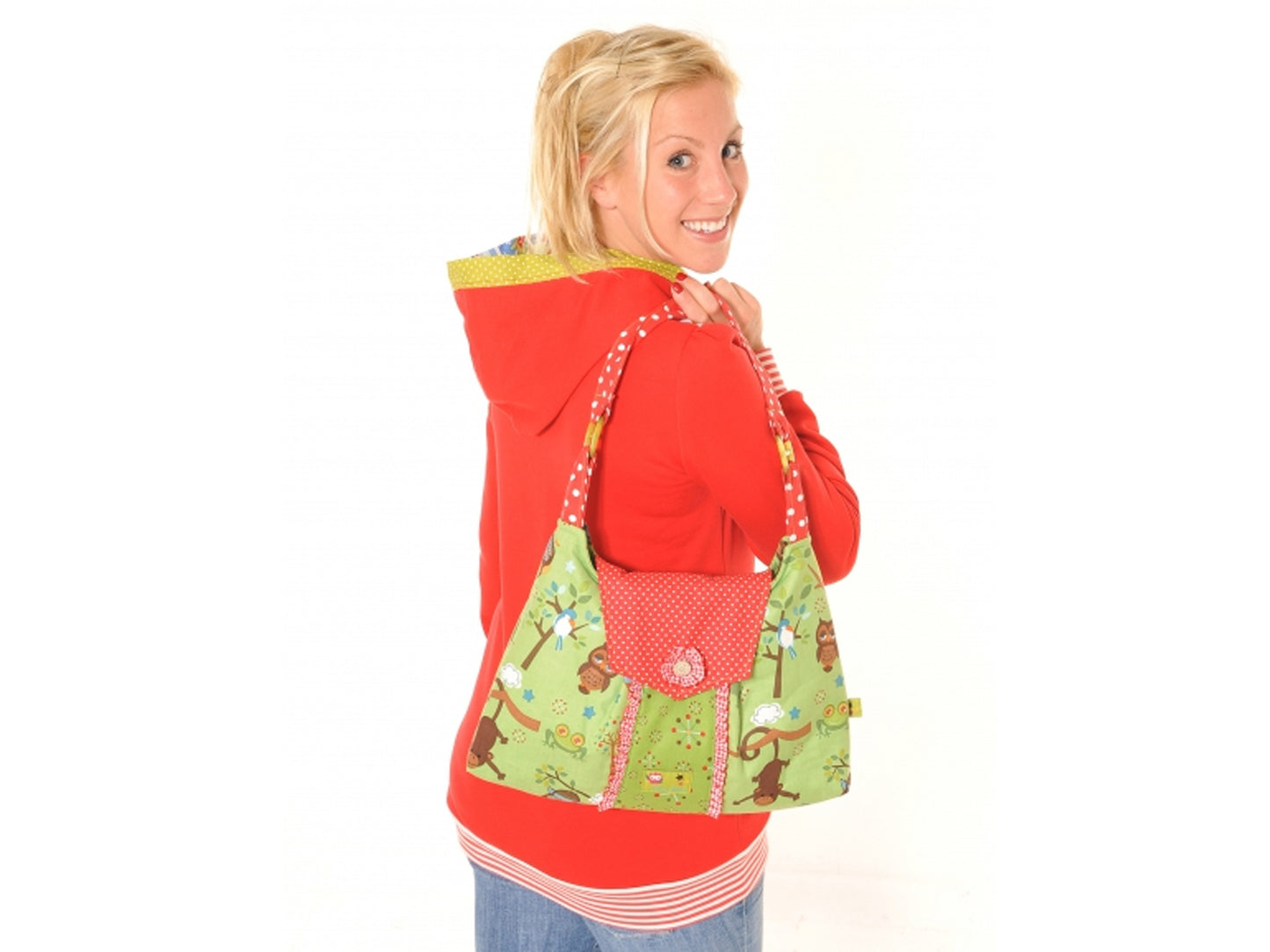 Miou Miou Florentine shoulder bag pattern showcased by a woman smiling while holding the colorful bag on her shoulder.