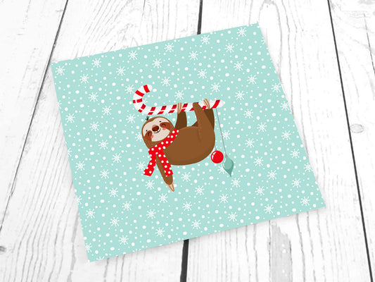 Merry Slothmas French Terry panel featuring a cheerful sloth with a candy cane on a snowflake background.