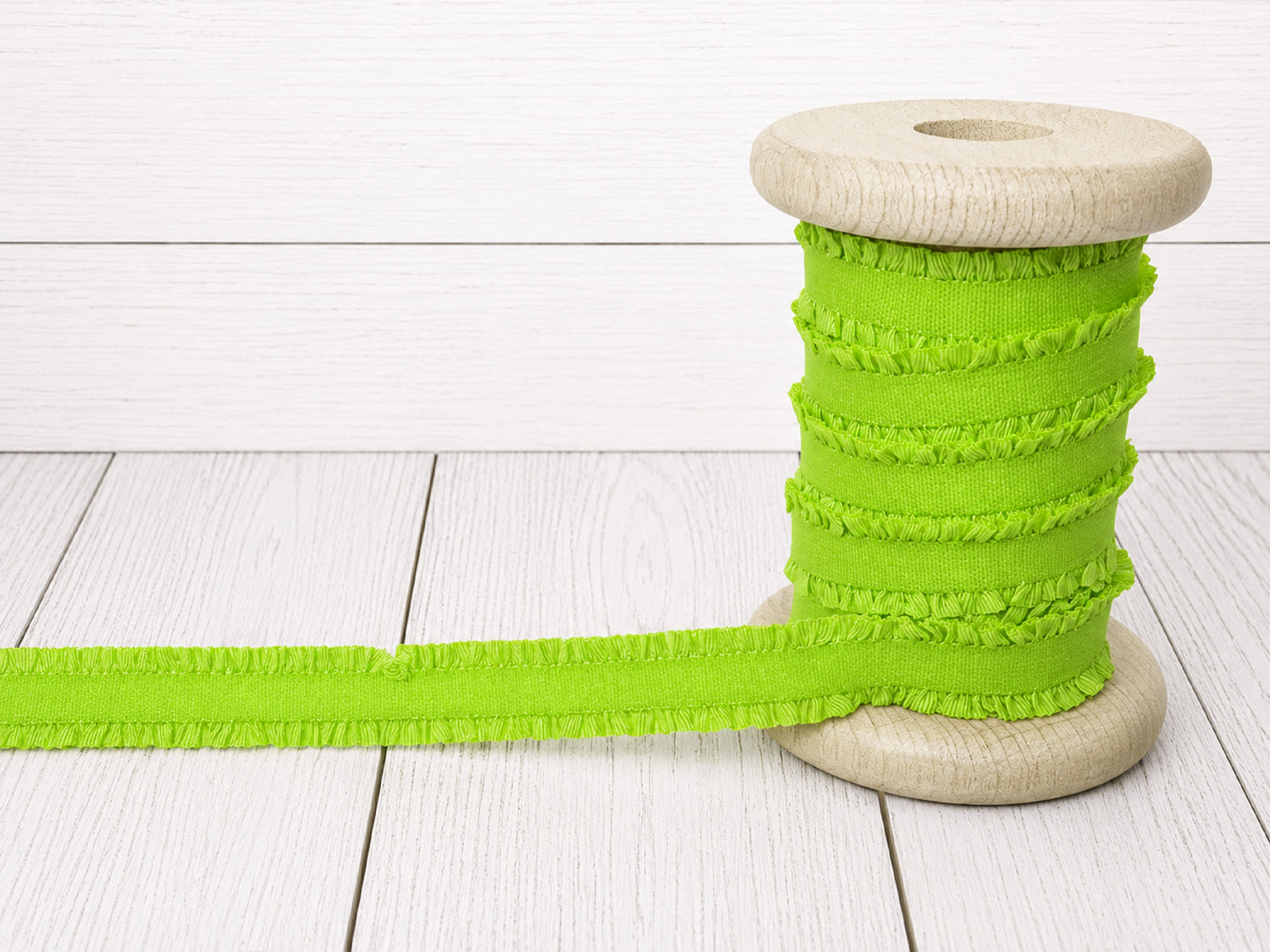 neongrün rüschen gummiband kaufen auf einer Holzspule mit feiner Rüschenstruktur für kreative Nähprojekte.