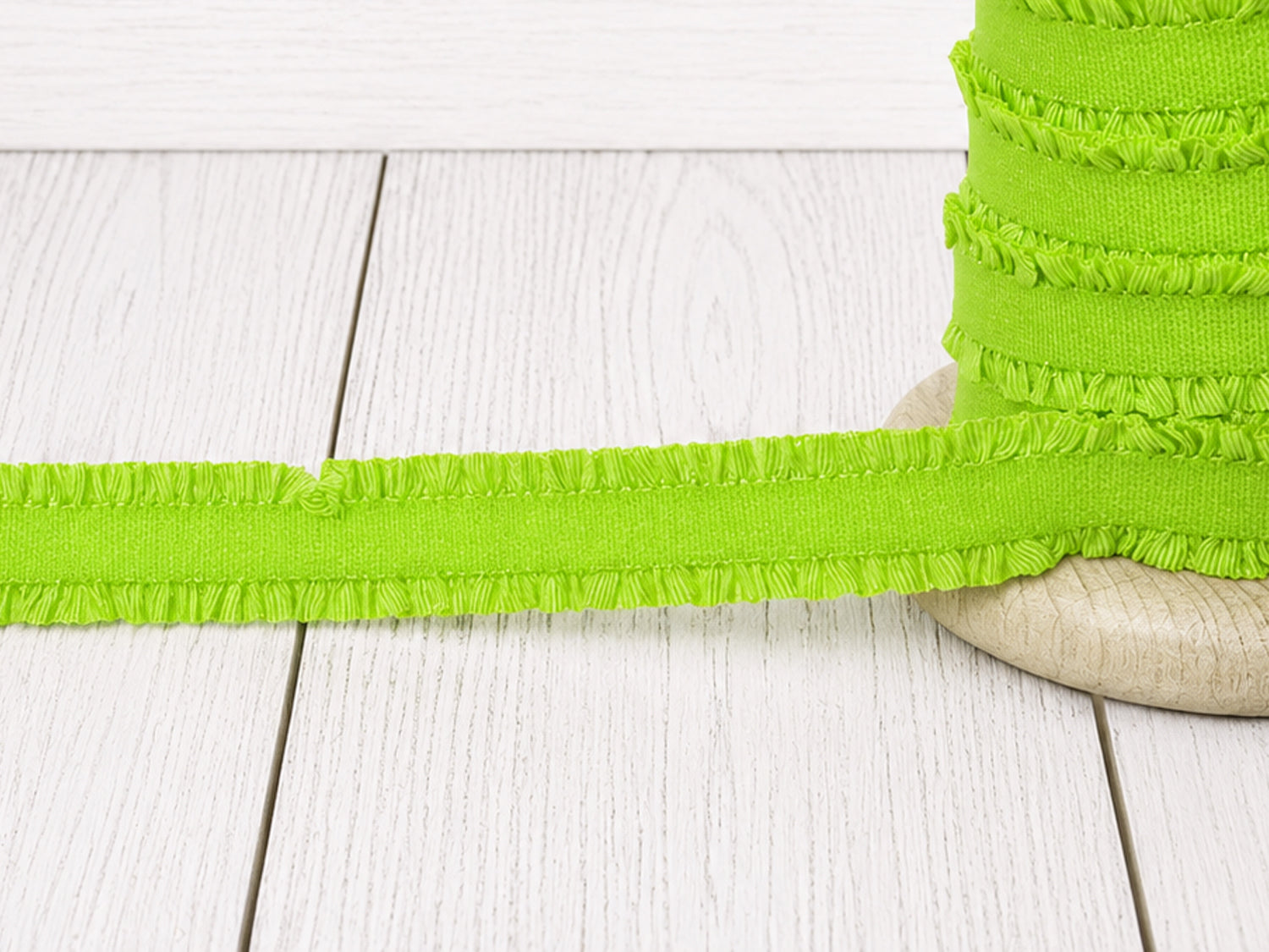 neongrün rüschen gummiband kaufen - elastisches Gummiband in neongrün auf einer Holzspule.