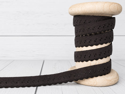 dunkelbraunes elastisches Einfassband auf einer Holzspule, mit Bogenkante und 11 mm Breite.