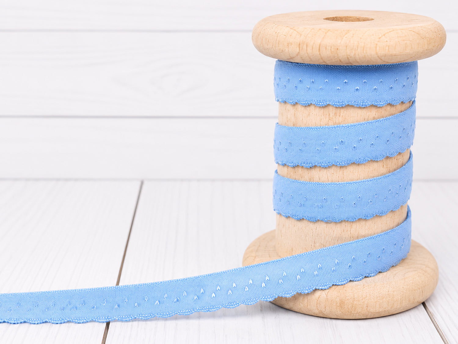 himmelblau elastisches Einfassband auf einer Holzspule mit dekorativer Bogenkante