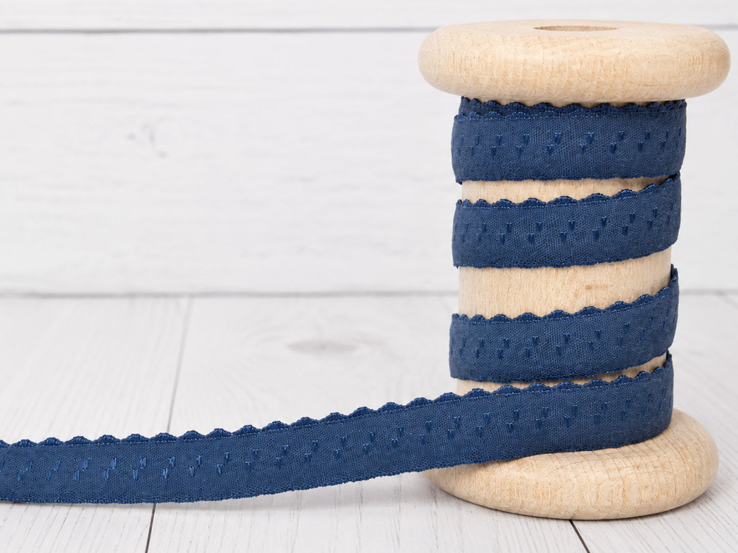 jeansblau elastisches einfassband auf einer Holzspule, breites 11 mm Band mit Bogenkante, waschbar bis 30 Grad.