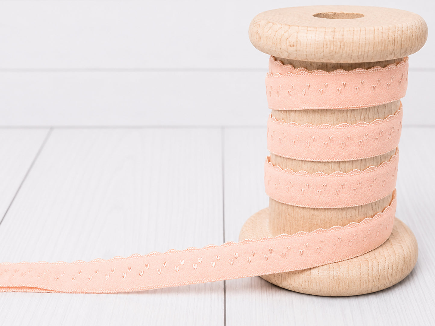 Elastisches Einfassband - lachs auf Holzspule, 11 mm breit, waschbar bis 30 Grad, Bogenkante.
