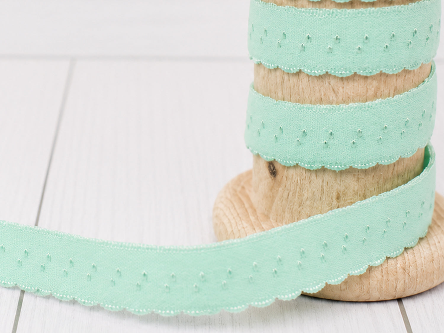 mint elastisches einfassband auf Spule, Bogenkante und sanfte mint Farbe, ideal für kreative Projekte.