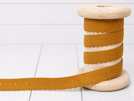 Elastisches Einfassband - ocker auf einer Holzspule mit Bogenkante, ideal für kreative Projekte.