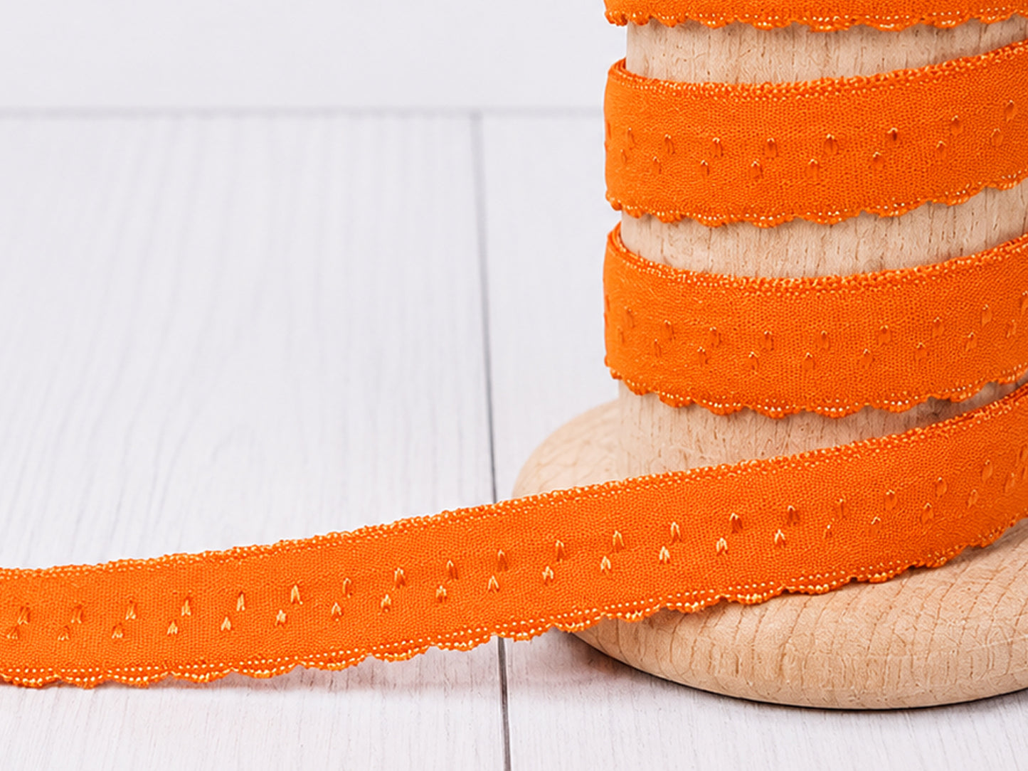elastisches einfassband orange auf Holzspule, attraktive Bogenkante und lebendige Farbe.