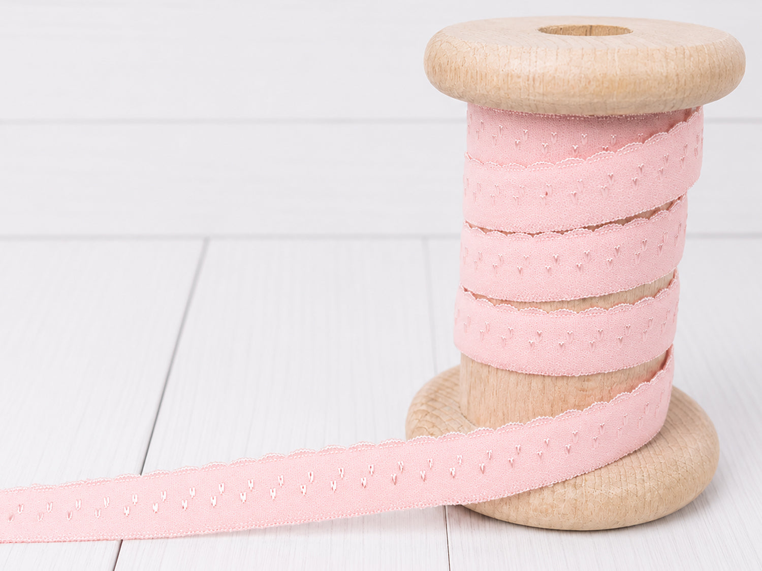 Elastisches Einfassband - rosé auf einer Holzspule, ideal zum elastisches einfassband rosé kaufen.