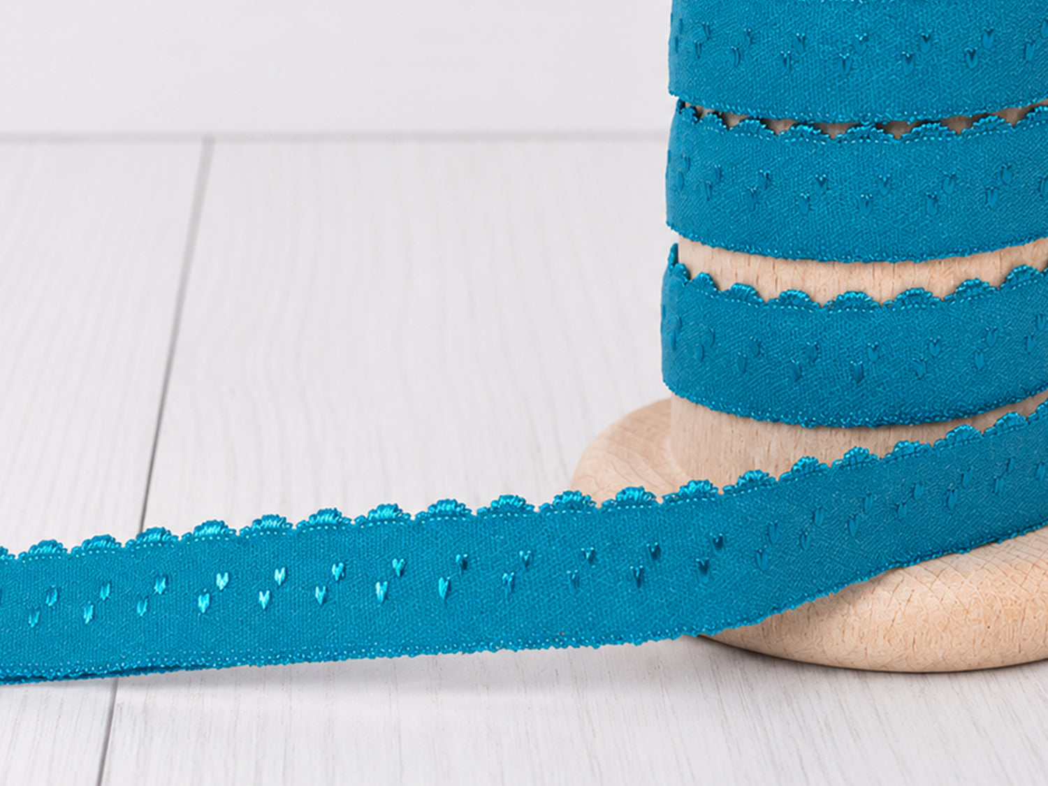 türkis elastisches einfassband auf Holzspender mit Bogenkante, 11 mm Breite, ideal für kreative Projekte.