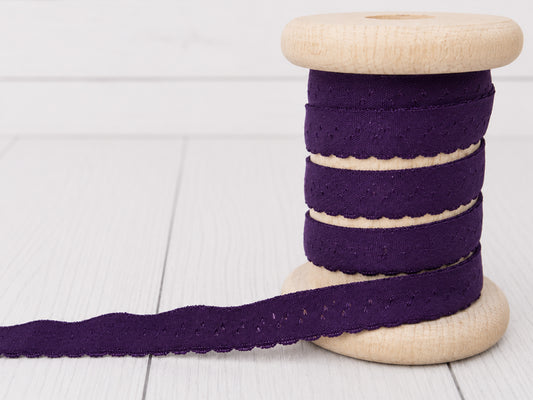 Elastisches Einfassband - violett auf einer Holzspule, ideal zum Nähen und Basteln.