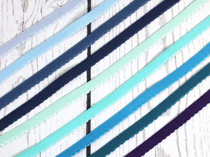 hellblaues Gummiband mit Bogenkante 12mm in verschiedenen Farben auf Holzuntergrund.