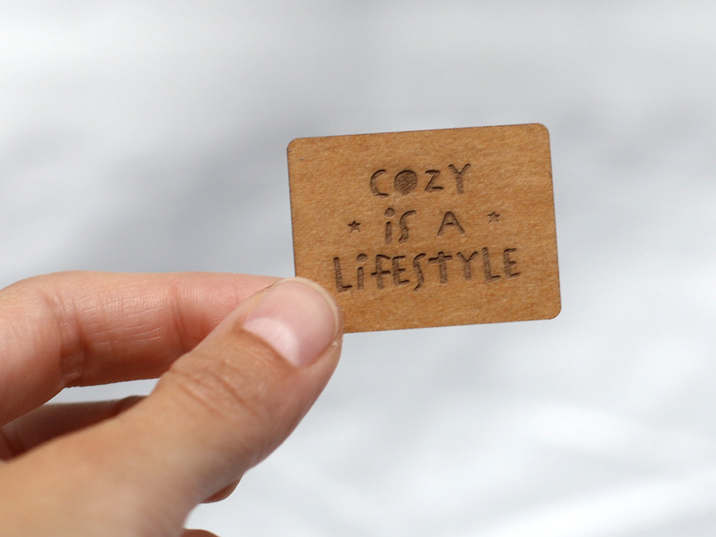 SnaPpap Label featuring a hand holding a cozy snap pap label with the phrase 'Cozy is a Lifestyle'.
