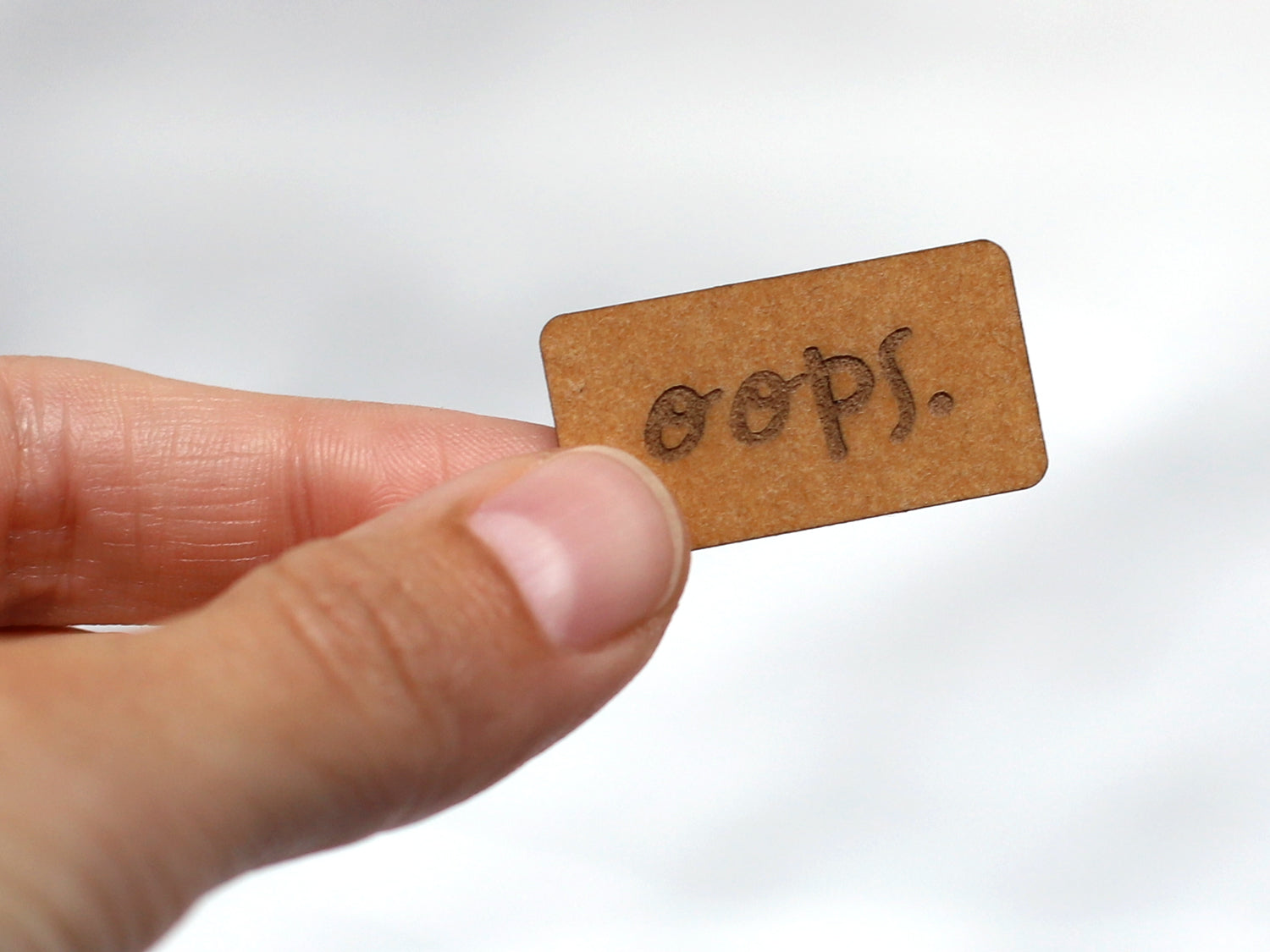 Vegan SnapPap label showing the word 'oops.' in a hands-on presentation, perfect for handmade projects.