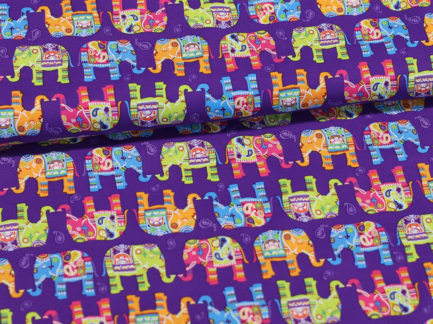 Patchworkstoff - Baumwolle Stoff - Bunte Elefanten, farbenfroher Elefantenstoff auf lila Hintergrund, ideal für kreative Nähprojekte.