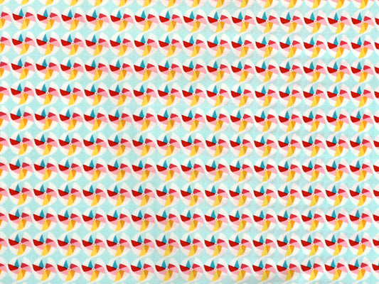 Patchworkstoff - Baumwolle Stoff - Pinwheel in buntem Muster mit roten, gelben und blauen Farben auf hellem Hintergrund.