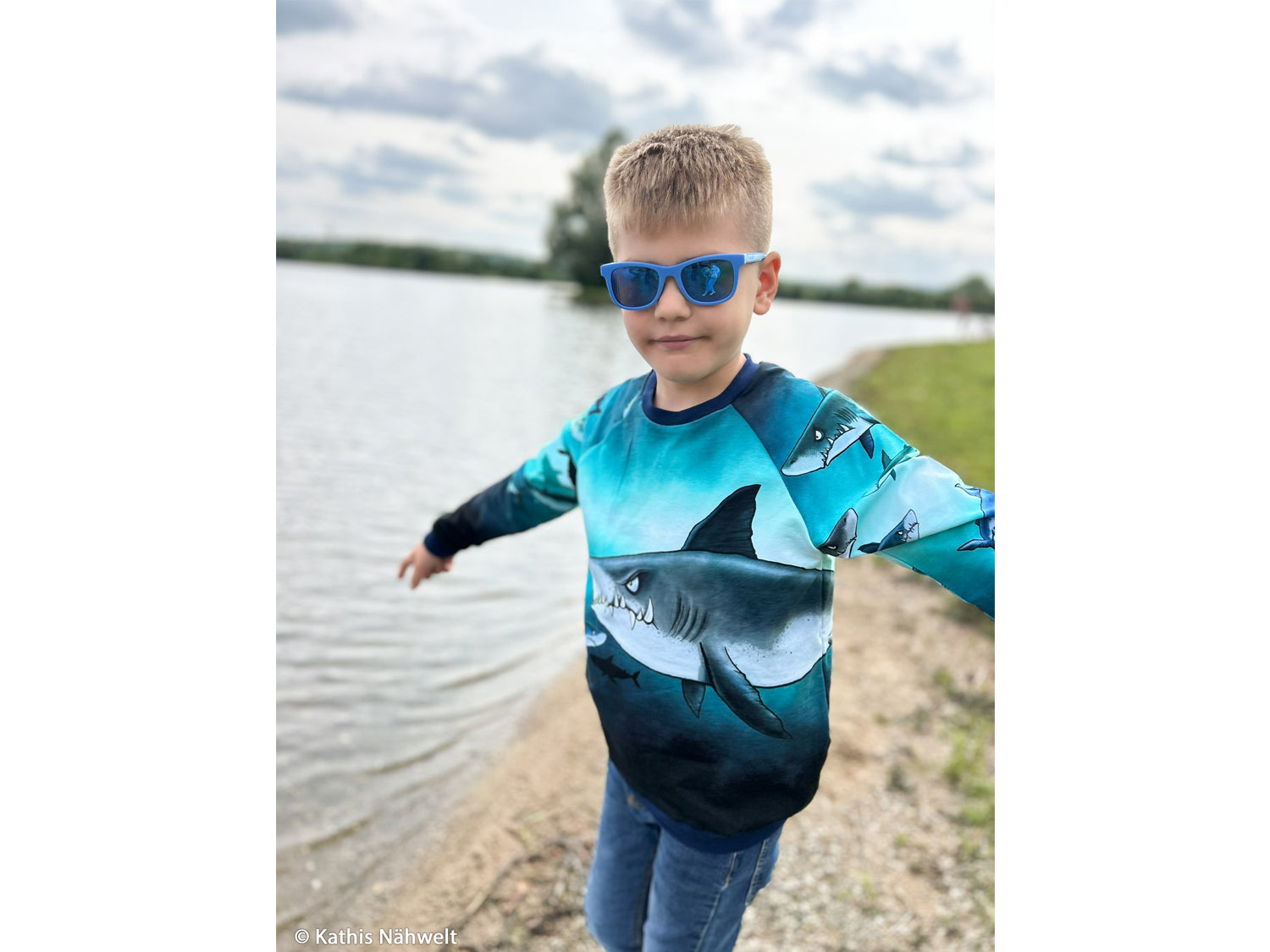 Child wearing French Terry PANEL - Thorsten Berger - Shark Tank, Big Shark sweatshirt by the water.