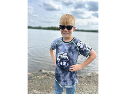 Jersey PANEL - Thorsten Berger - Mussel Mo, Need More Vitamin Sea shirt on a boy at the lake, enjoying the outdoors.