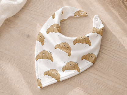 Cute bib featuring adorable croissant designs, perfect for stylish baby outfits.
