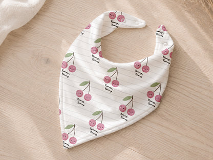 lightweight cherry print jersey fabric in a stylish bib design with pink cherries on a white background.