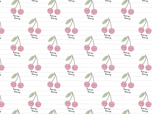 Lightweight cherry print jersey fabric featuring adorable cherries and playful text design on a soft background.