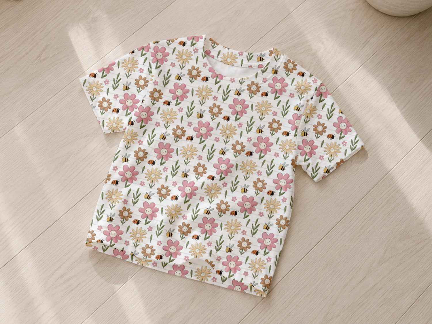 leichter Sommer Jersey Stoff mit buntem Blumenmuster auf T-Shirt gelegen auf Holzboden.