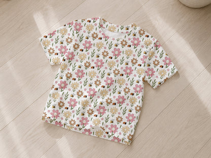 leichter Sommer Jersey Stoff mit buntem Blumenmuster auf T-Shirt gelegen auf Holzboden.