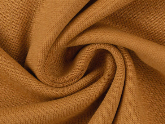 Uni Jersey ocker sale fabric close-up showcasing soft, durable material for comfortable wear.