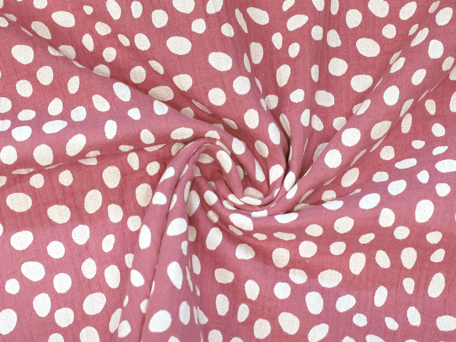 altpink musselin fabric featuring playful white polka dots on a soft background.