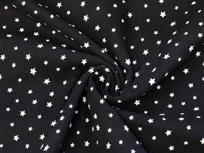 black star muslin fabric featuring a black background with white stars, perfect for various sewing projects.