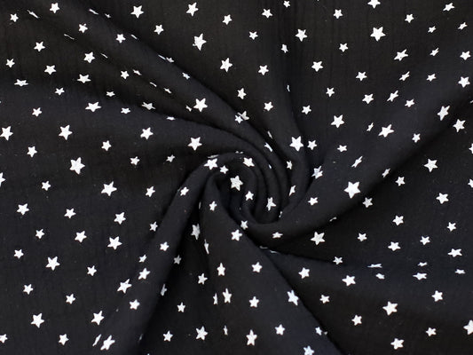 black star muslin fabric featuring a black background with white stars, perfect for various sewing projects.