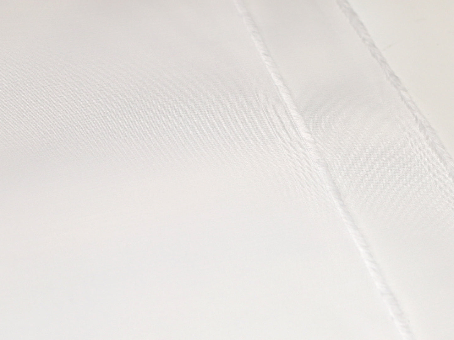 Fester, strukturierter Stoff in wollweiß, mit klarer Textur und feinen Nähte für hochwertige Anwendungen.