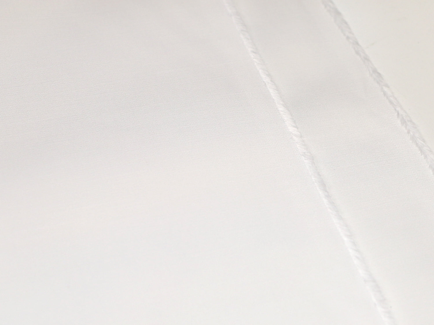 Fester, strukturierter Stoff in wollweiß, mit klarer Textur und feinen Nähte für hochwertige Anwendungen.